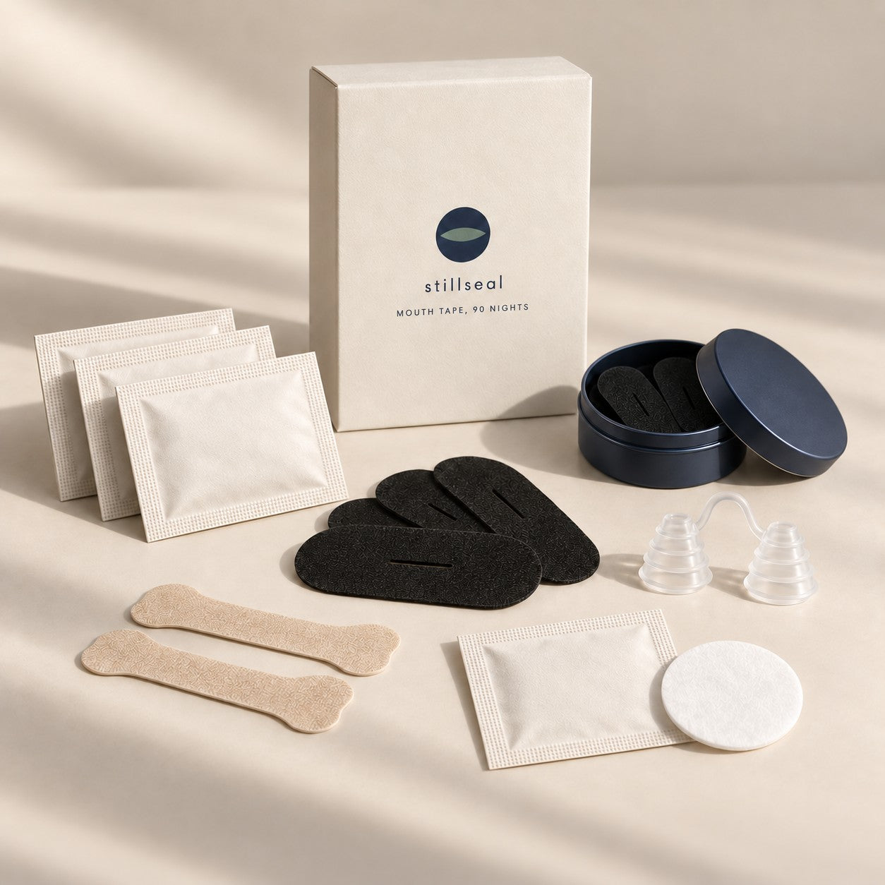 Everything in the Stillseal starter box laid out: box, three packs of strips, nose strips, nose vents, prep pad sachet and the tin